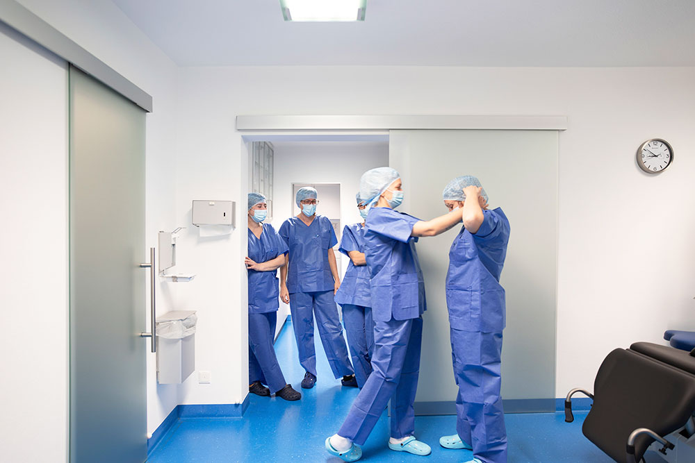 OP-Team Vorbereitung Das OP-Team in blauen Kitteln bereitet sich auf die OP vor.